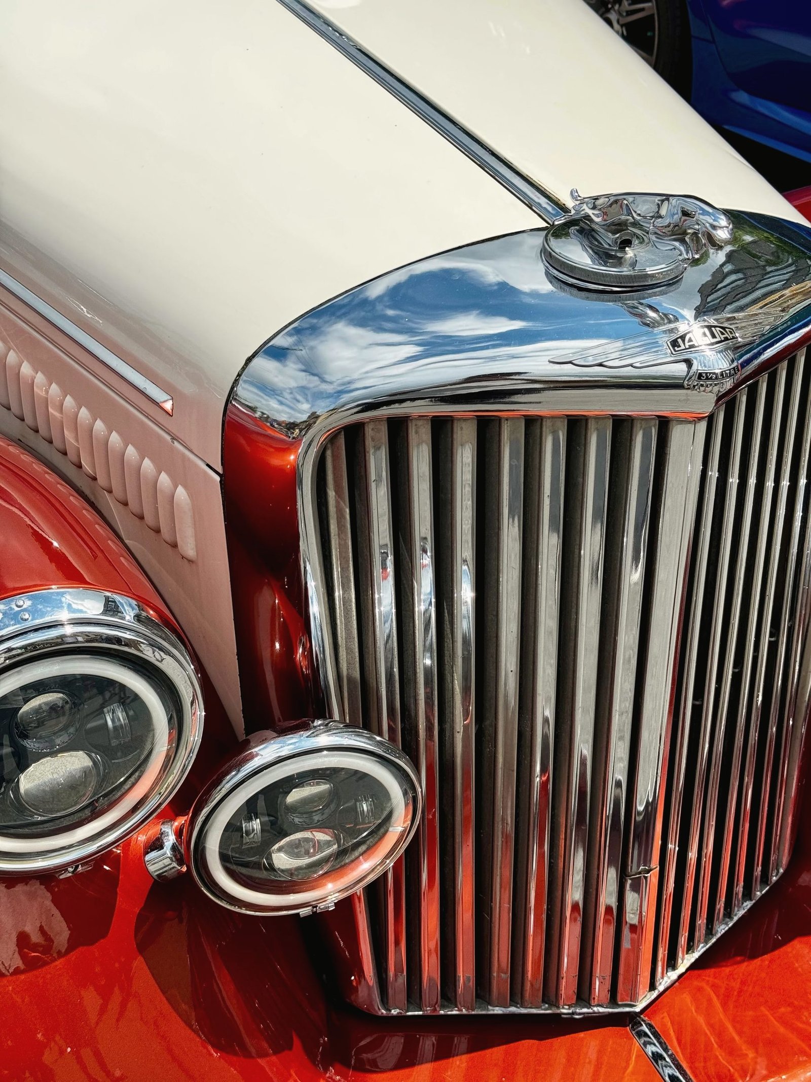 The upright chrome grille and lamps of a vintage car.