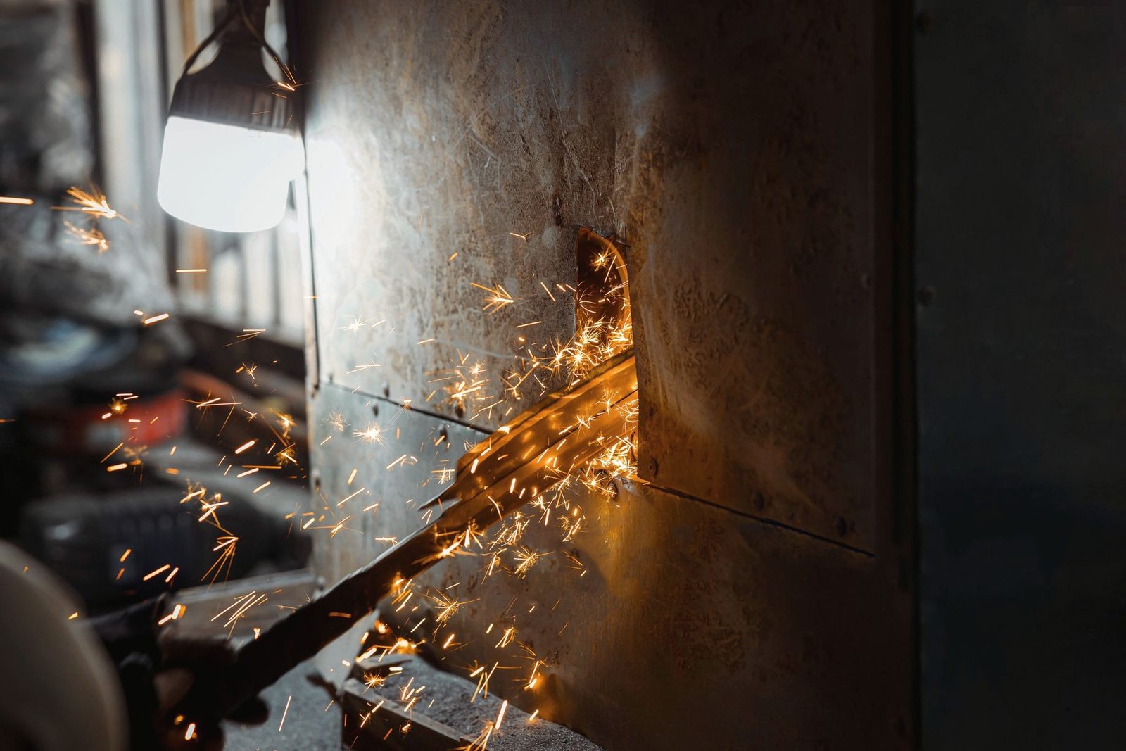 Sparks thrown off metal being ground in a workshop.