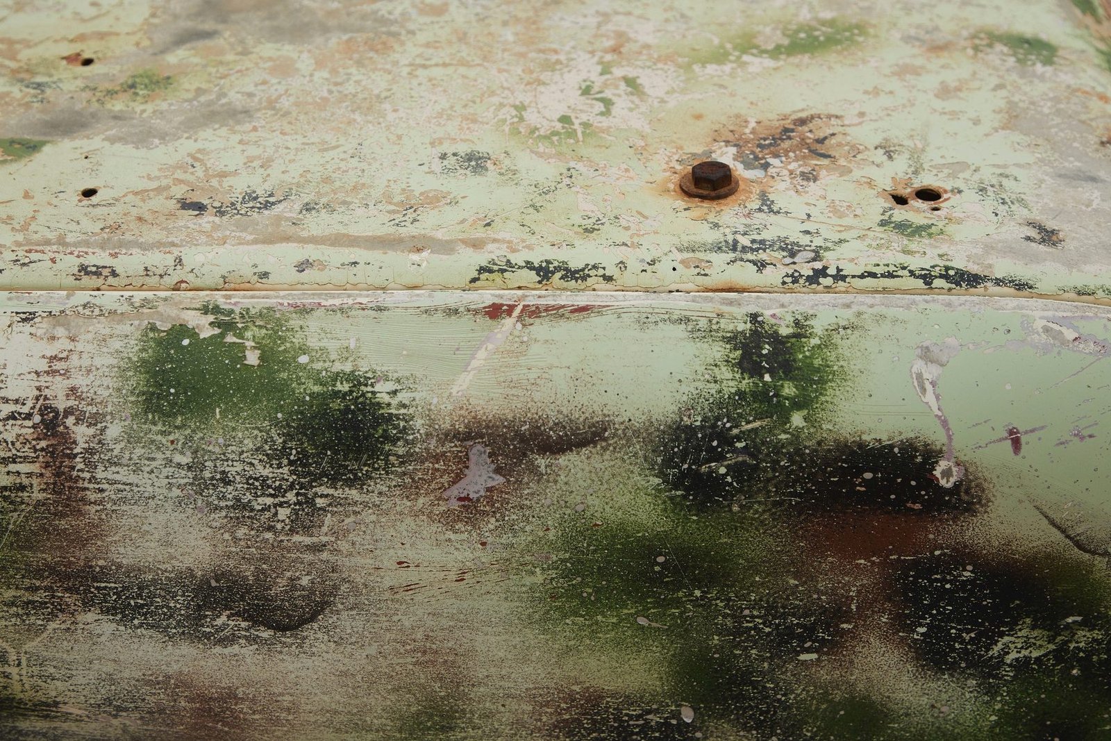 A corroded metal surface, pitted and discoloured.